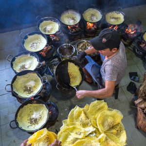 Man cooking bánh xèo, a traditional Vietnamese stuffed rice pancake